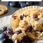 Image for Pinterest of a moist tender blueberrry sourdough muffin topped with an oat streusel with a bite lifted with a fork.