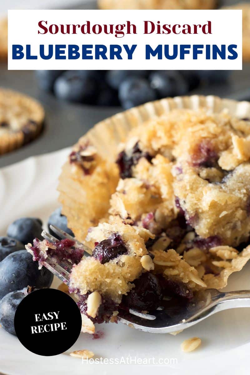 Image for Pinterest of a moist tender blueberrry sourdough muffin topped with an oat streusel with a bite lifted with a fork.