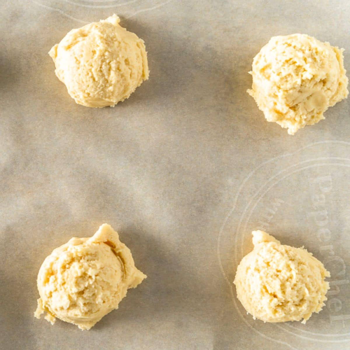 Scooped crumble cookie dough on a baking sheet. Hostess At Heart
