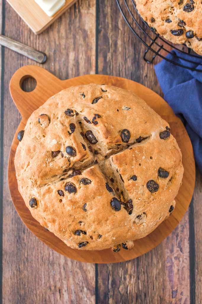 Top down view of a round loaf of Irish soda bread dotted with raisins.