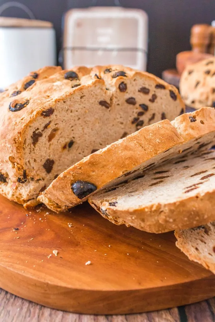 Side view of a sliced loaf of sourdough bread on a cutting board