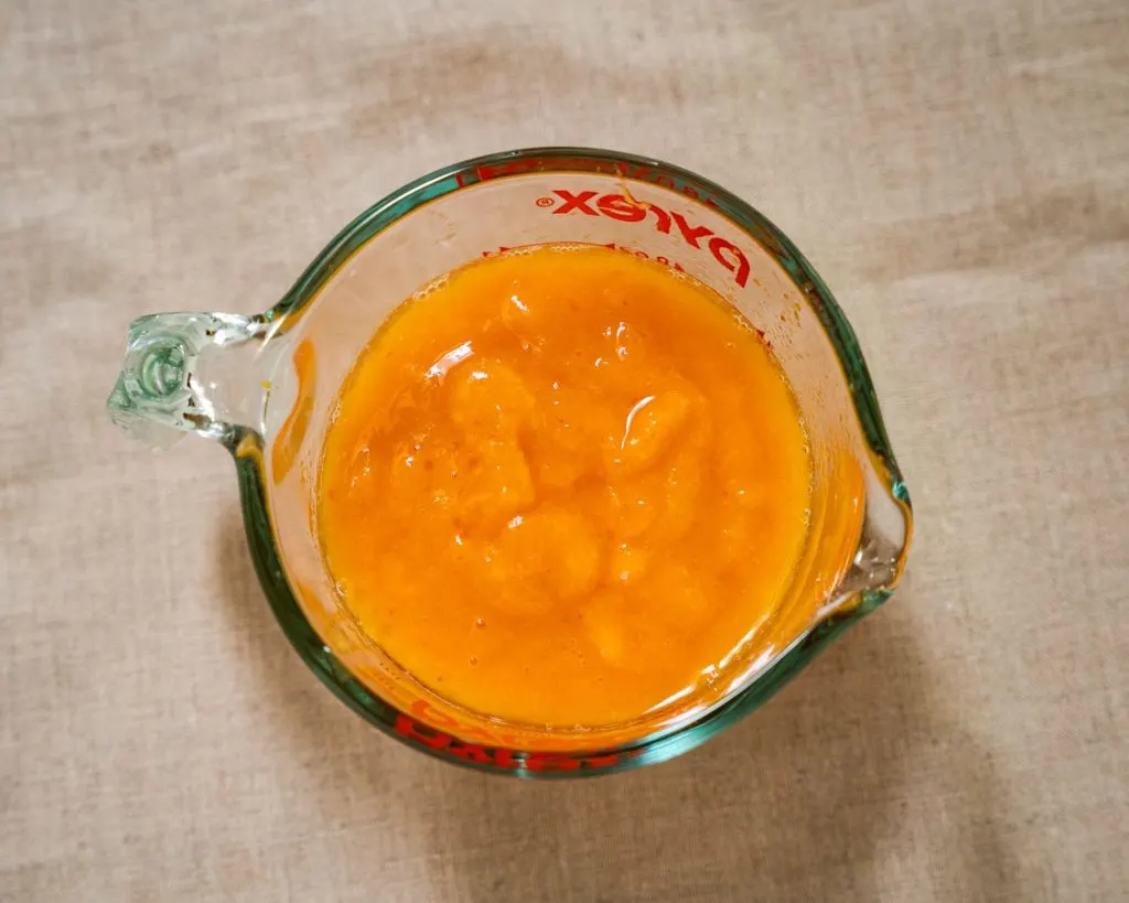 Fresh peaches pureed in a measuring cup