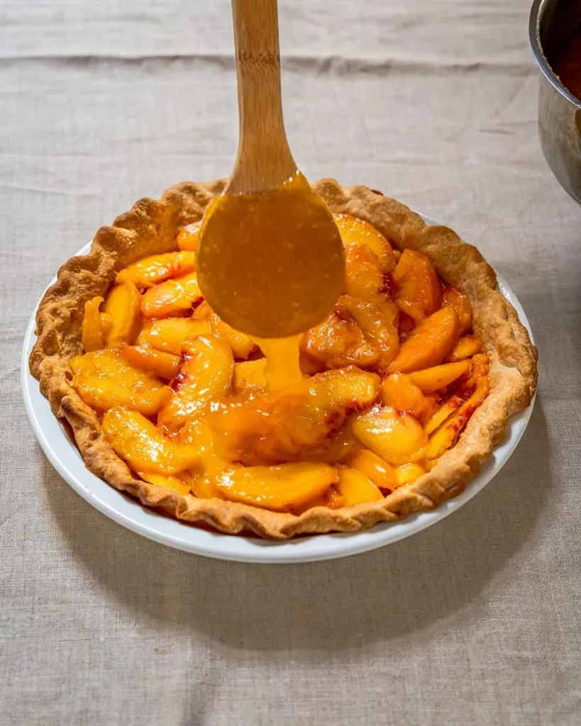 Thickened glaze applied to fresh peach pie