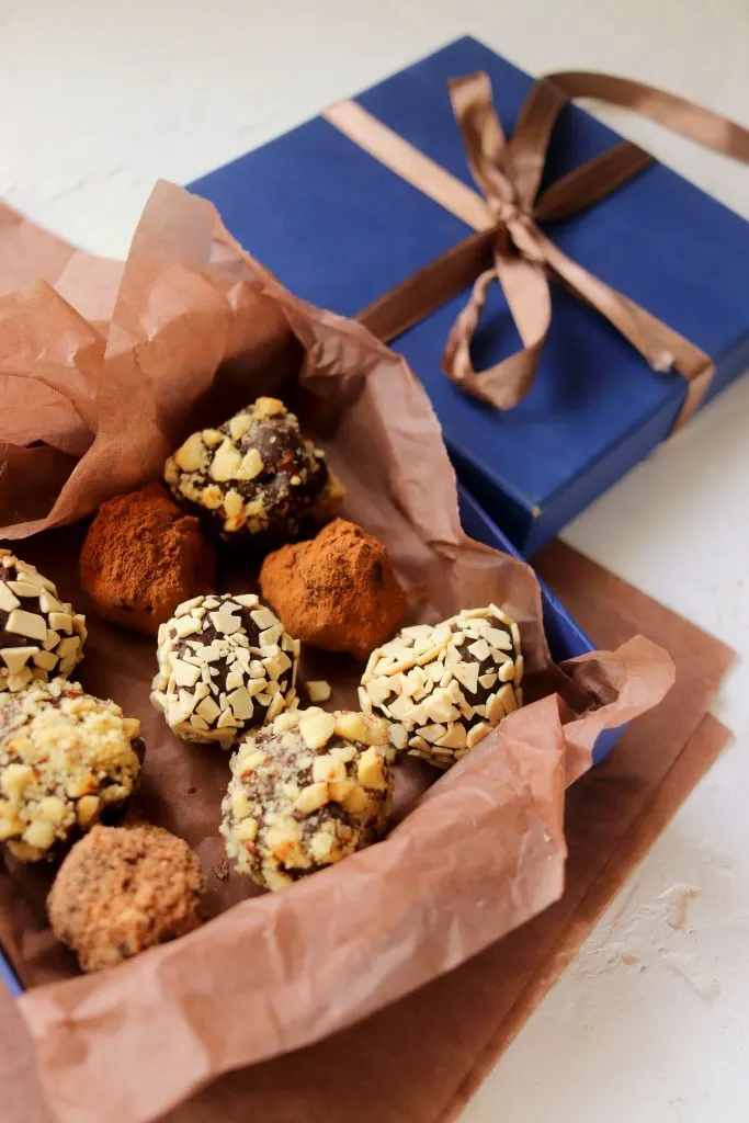 Box of finished homemade chocolate truffles with a ribbon.