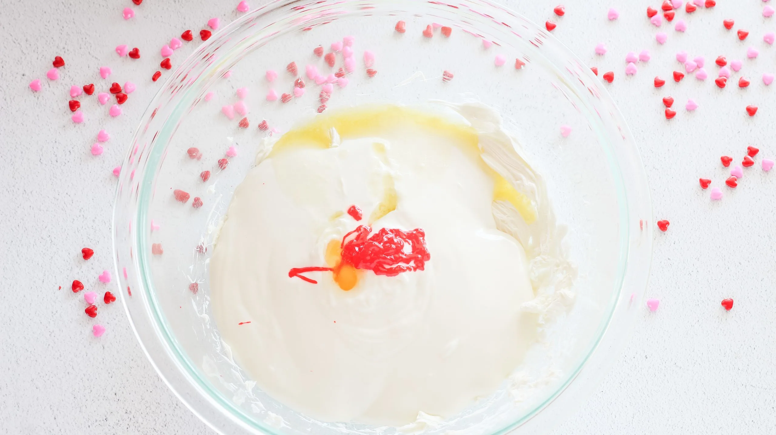 Melted almond bark, food coloring and butter added to a bowl. Hostess At Heart