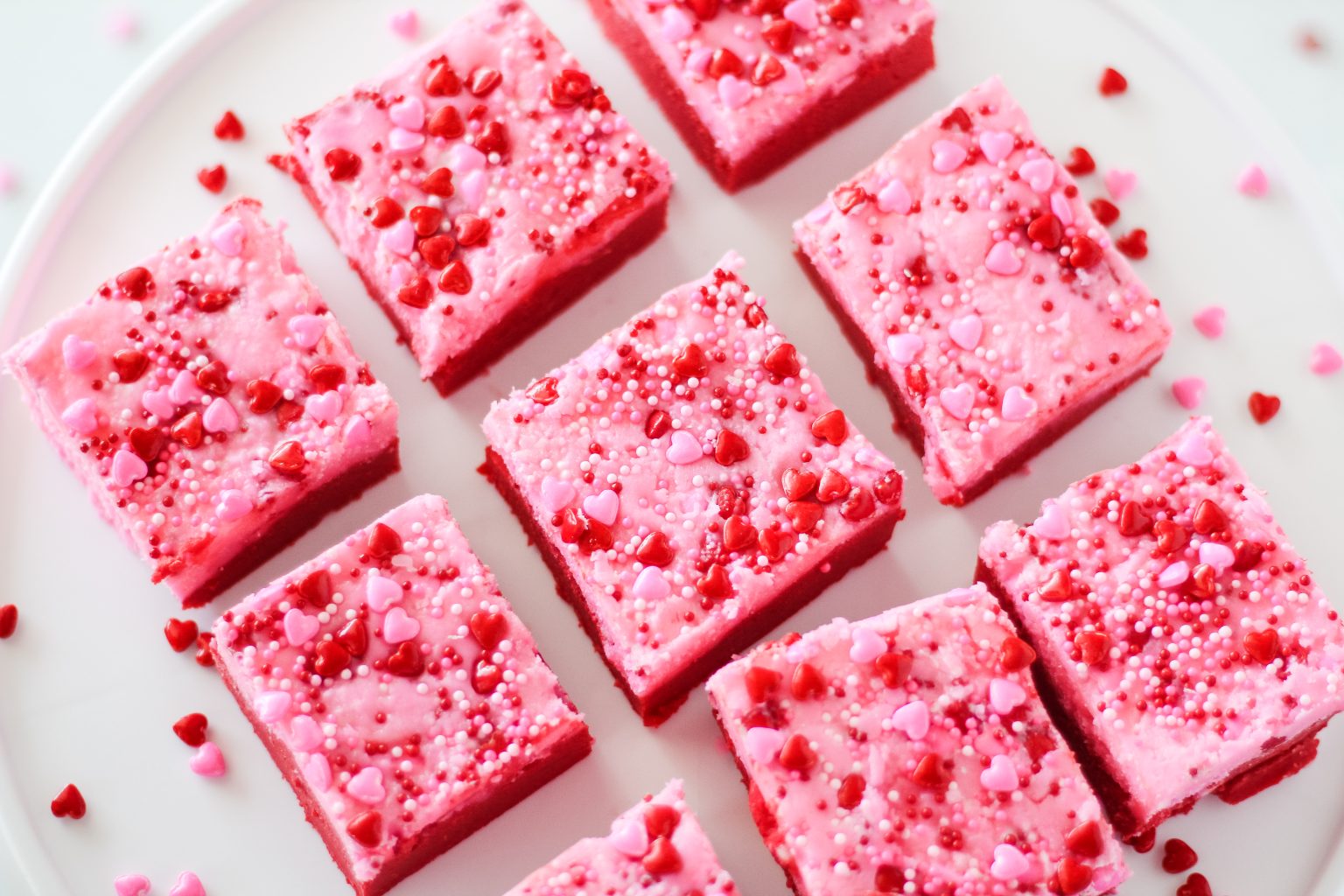 Top down view of sprinkles topping pink and red fudge squares. Hostess At Heart