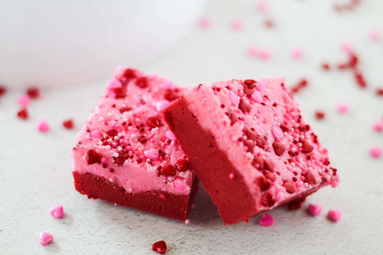 Two square pieces of red and pink fudge stacked together - Hostess At Heart