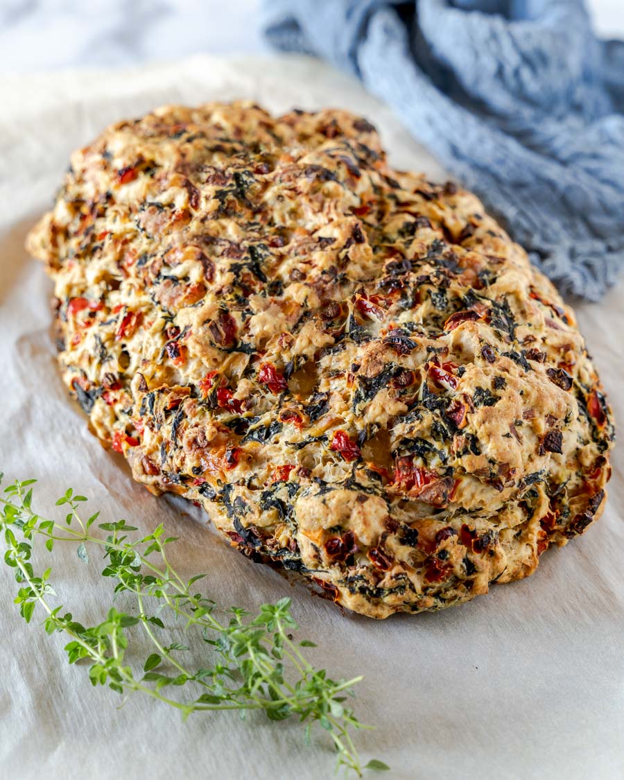 Top down view of a loaf of homemade bread loaded with spinach, and red pepper. Hostess At Heart