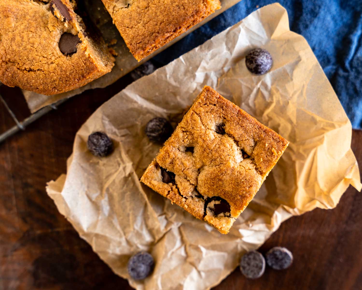 Top down view of a cookie bar with chocolate chips sitting on a piece of parchment paper.