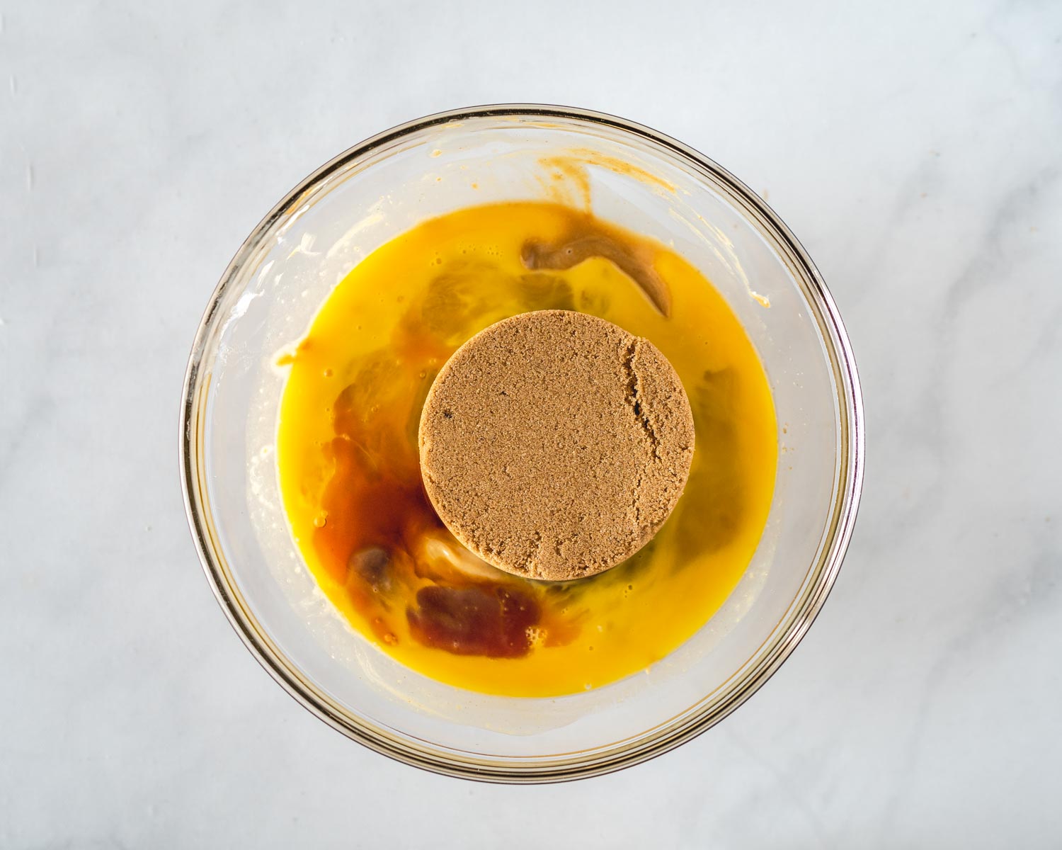 Brown sugar added to a bowl of melted butter, egg, and vanilla.