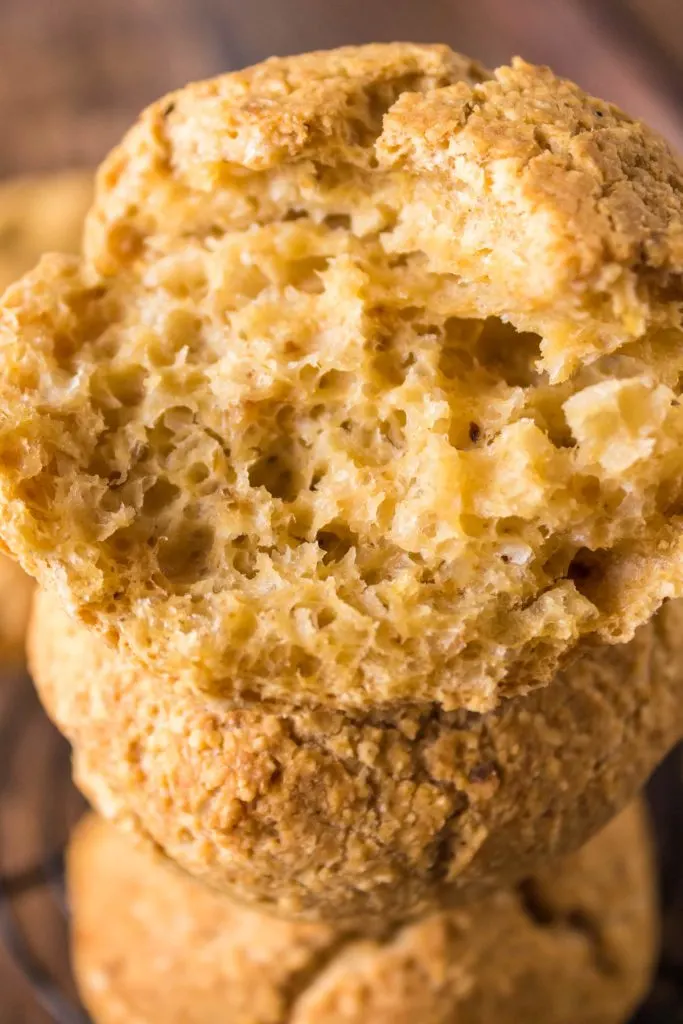 A baked roll broken in half showing a soft open crumb.