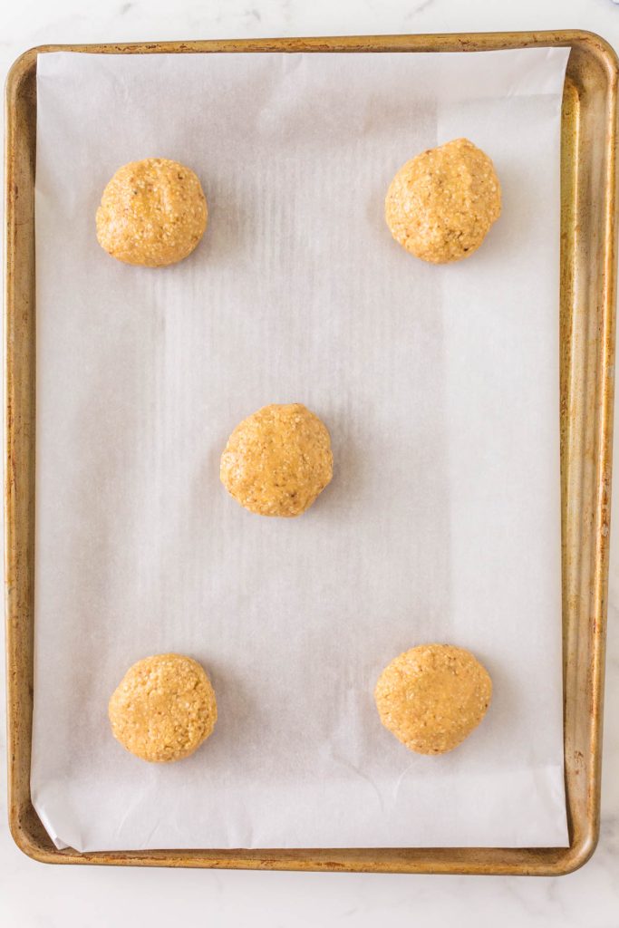 5 formed matzo rolls on a parchment-paper lined baking sheet.