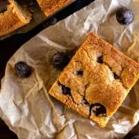 Top down view of a cookie bar with chocolate chips sitting on a piece of parchment paper.