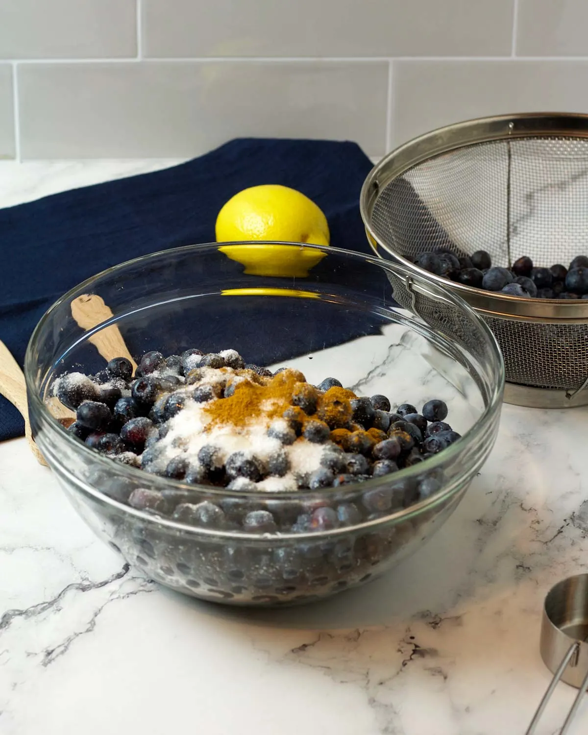 Ingredients in a bowl: blueberries, sugar, cinnamon, vanilla, and lemon juice.