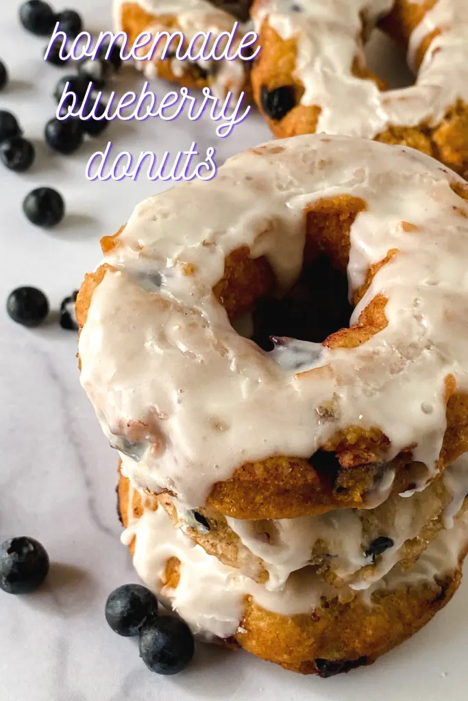 top angled view of a stack of blueberry donuts topped with glaze.