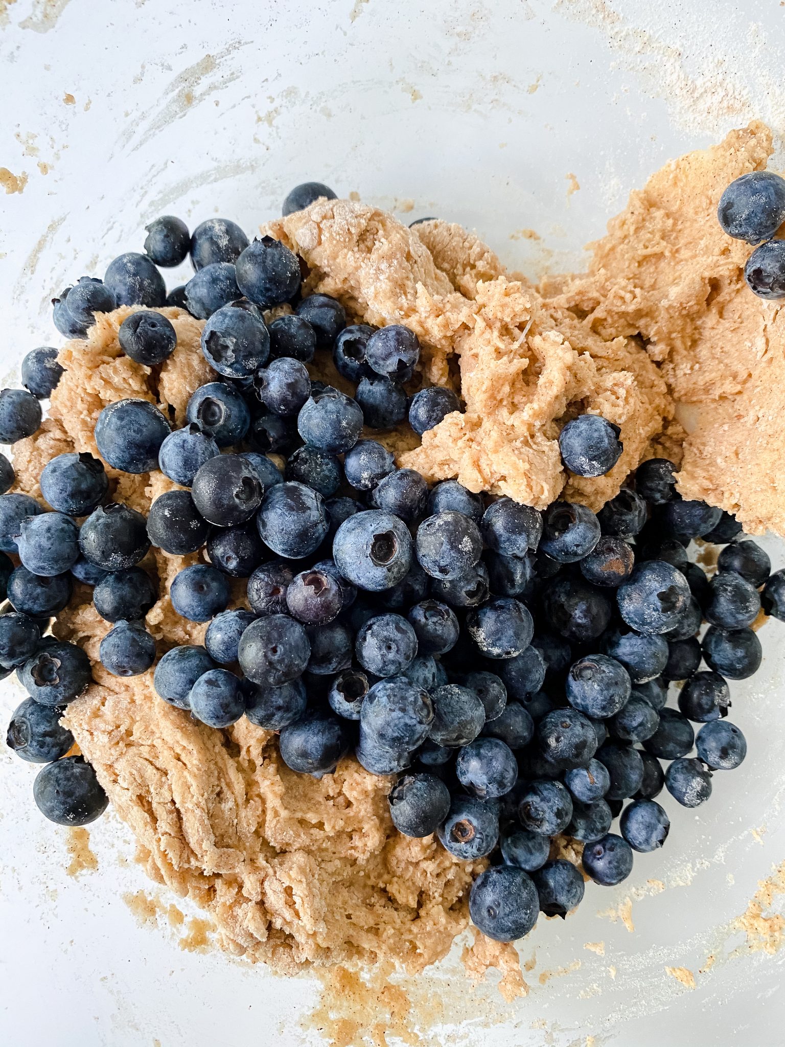 Blueberries on top of donut dough before folding.
