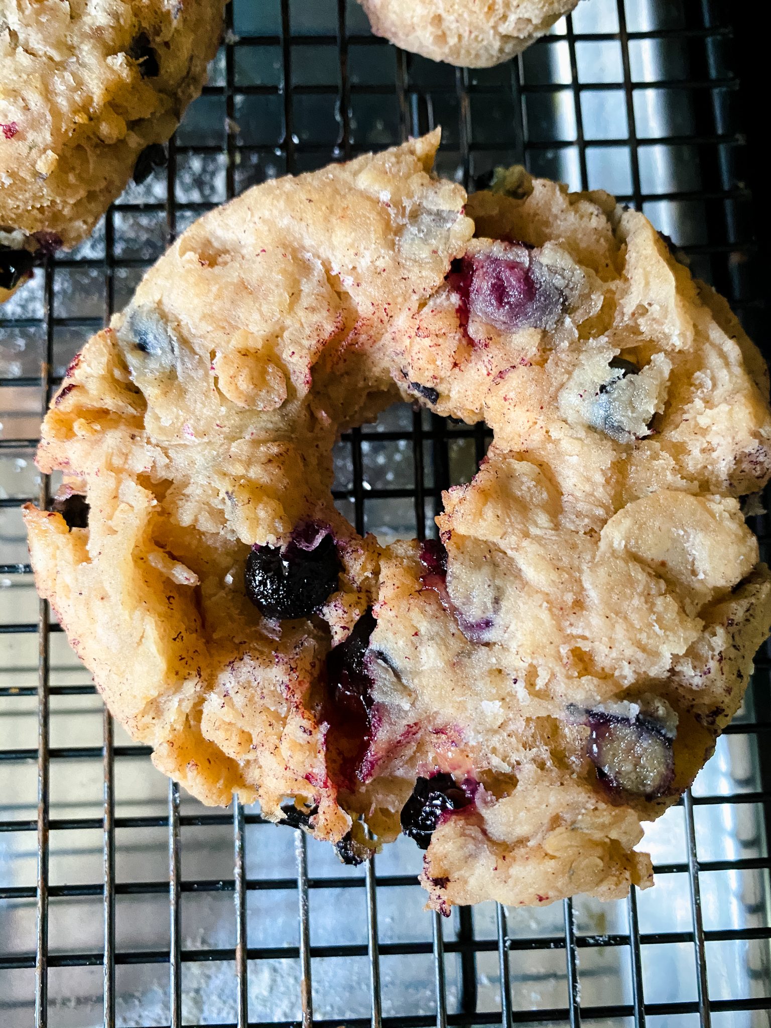 Top down view of a freshly fried donut filled with blueberries.