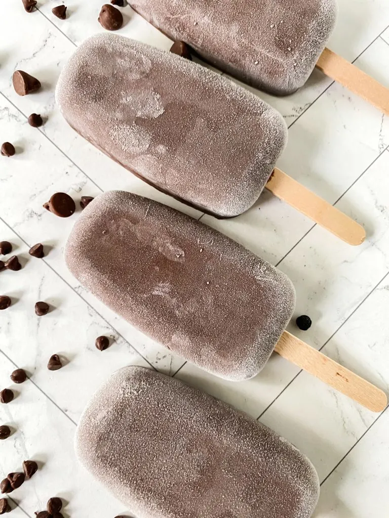 Four frozen and frosty fudge pops on a tray. 