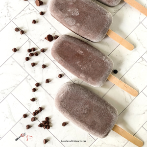 Top down view of frozen chocolate popsicles surrounded by chocolate chips