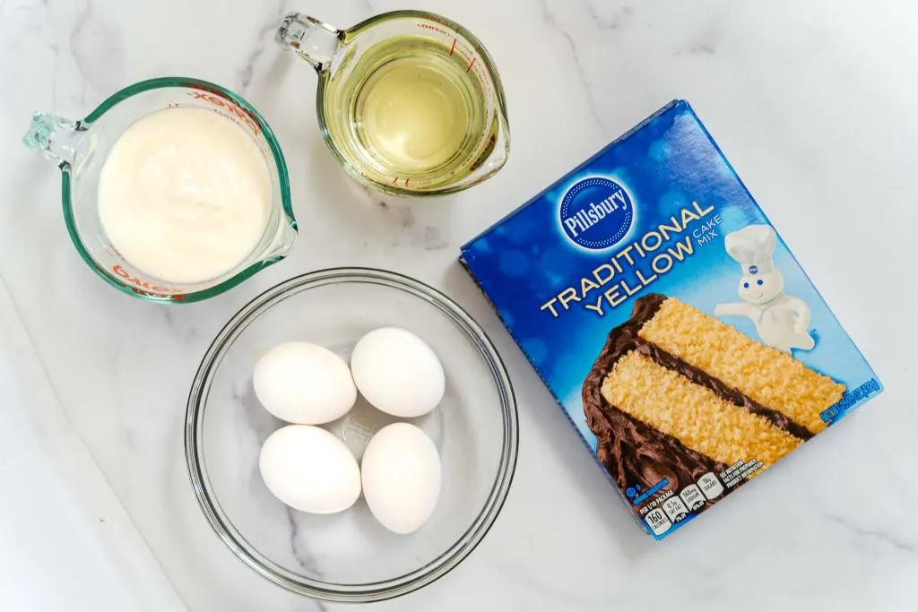 Ingredients for a honey cake including a yellow cake mix, eggs, vegetable oil and sour cream