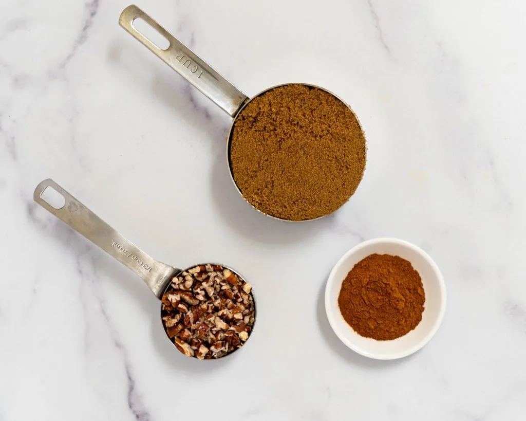 Containers holding brown sugar chopped pecans, and cinnamon.