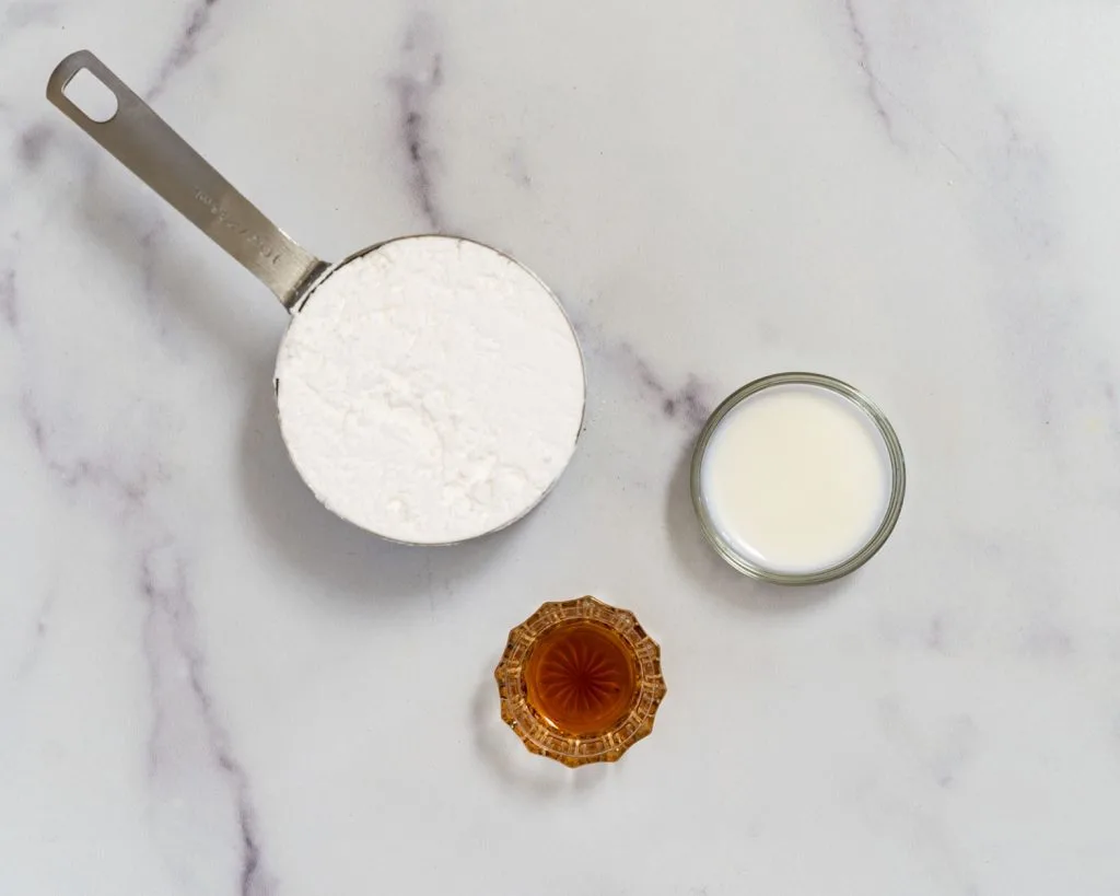 containers holding powdered sugar, milk and vanilla to make glaze.