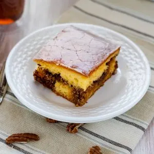 3/4 view of a slice of honeybun cake with a pecan cinnamon filling covered with a sweet glaze.