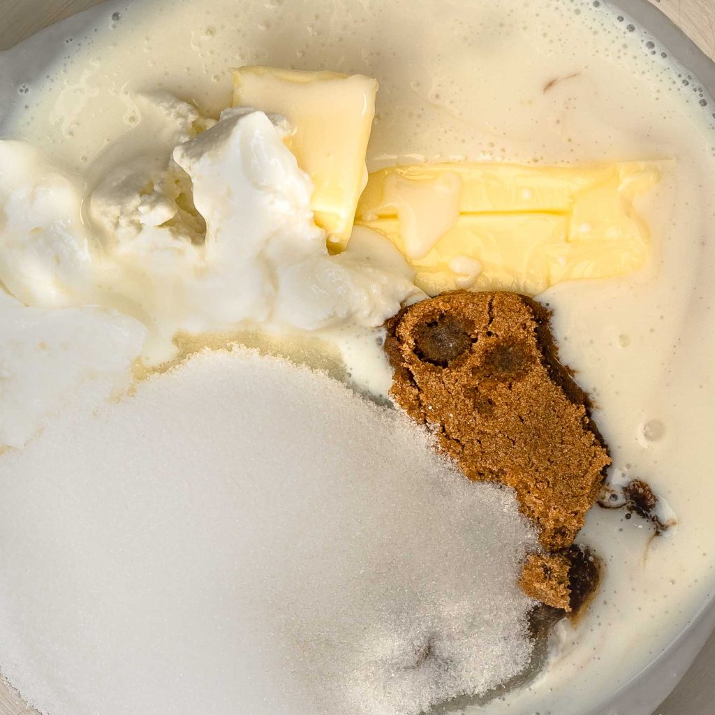 Mixture in a bowl showing butter, brown sugar, white sugar, and foam.