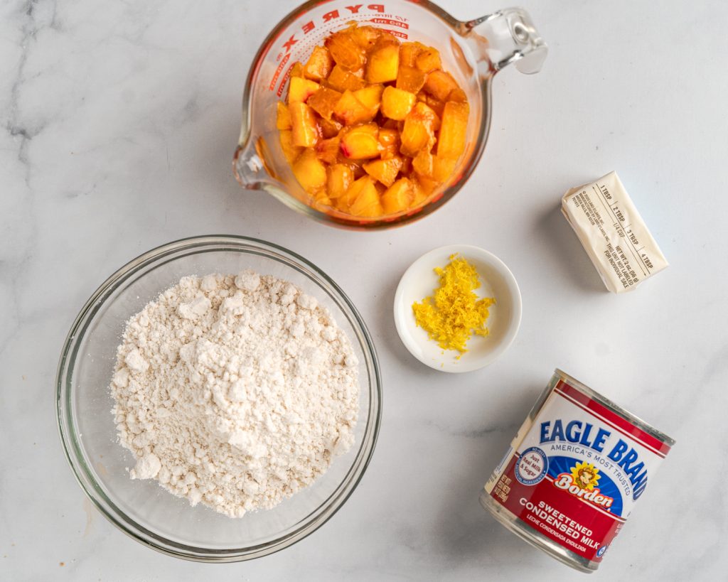 Ingredients. Diced peaches, biscuit mix, sweetened condensed milk, butter, and lemon zest.
