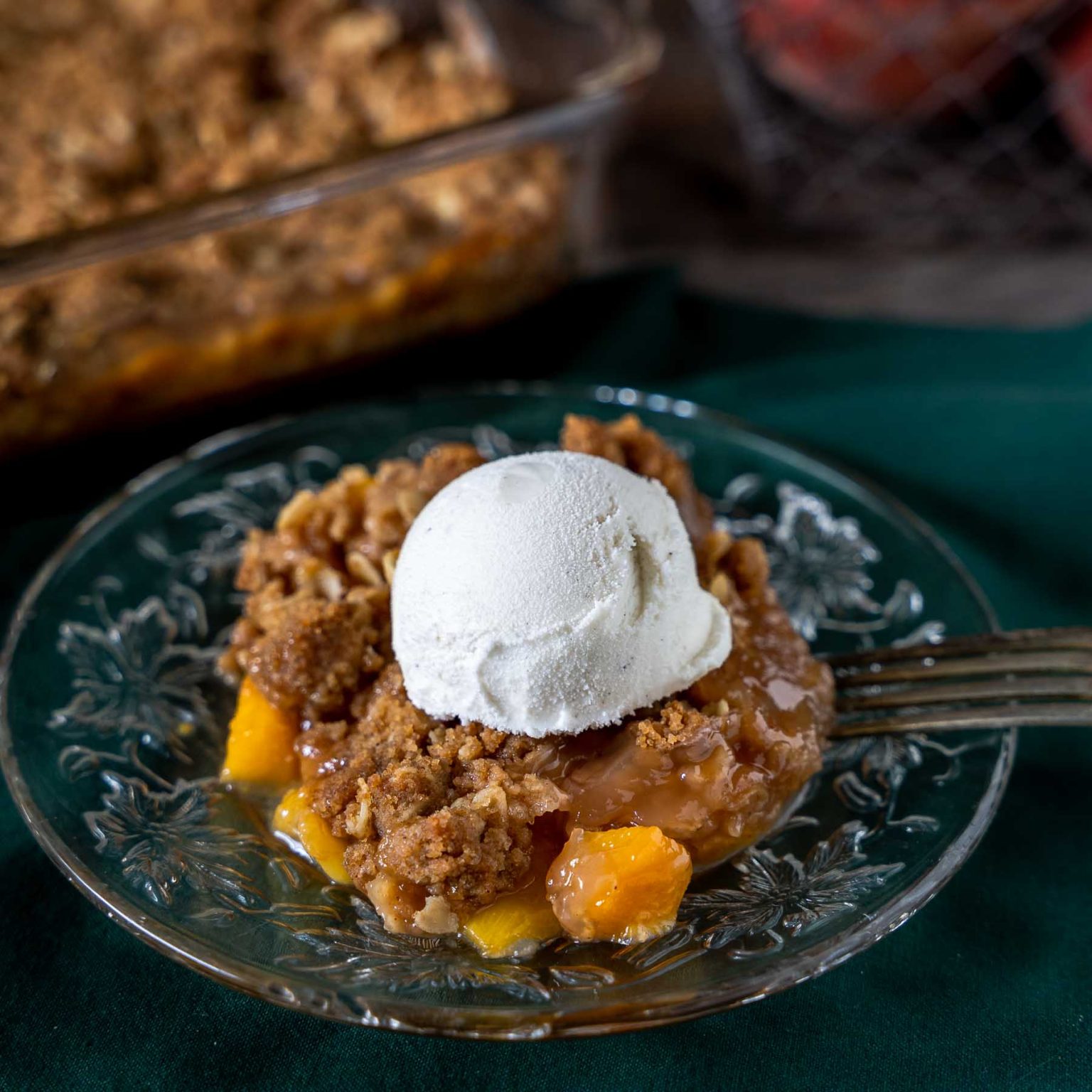 Beautiful close-up of a single serving of peach crumble on a plate.