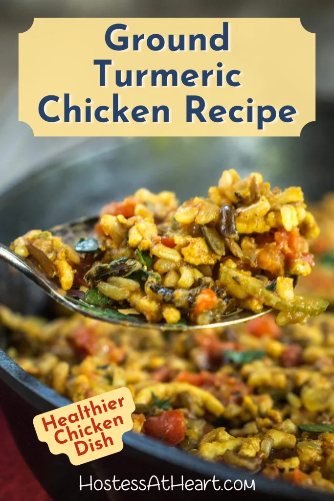 Close up side view of a spoon holding ground turmeric chicken over a skillet.