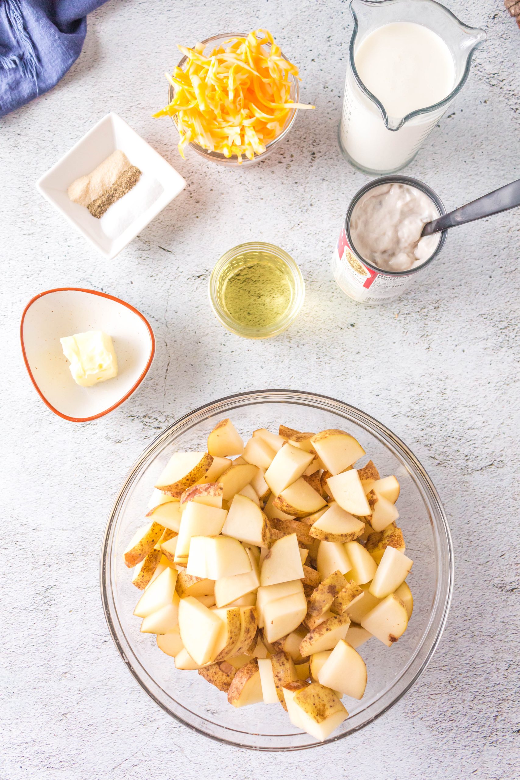 Cheesy potatoes casserole ingredients: Shredded cheese, real potatoes, butter, oil, mushroom soup, and cream. Hostess At Heart