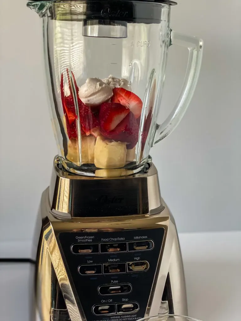 Fruit in a blender. Strawberries, Bananas, solid coconut milk.