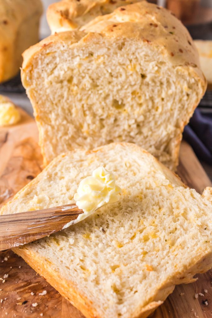 Close-up slice of cheddar bread with butter.