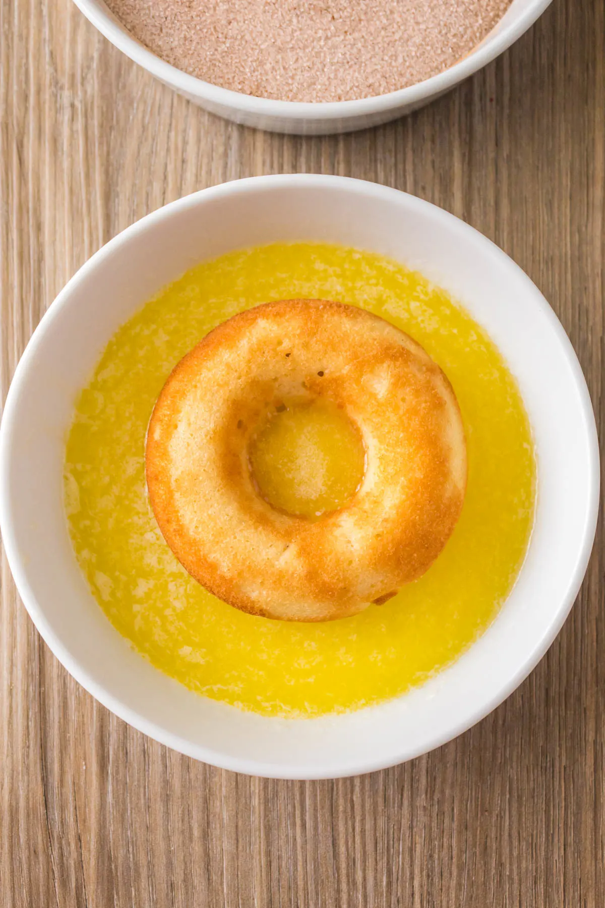 Baked donut sitting in melted butter.