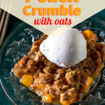 A slice of easy peach crumble on a plate topped with a scoop of ice cream.