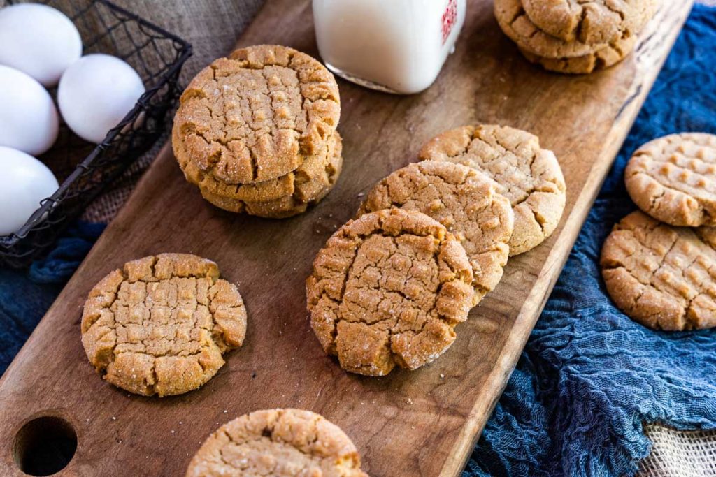 Homemade peanut butter cookies sitting on a cutting board.