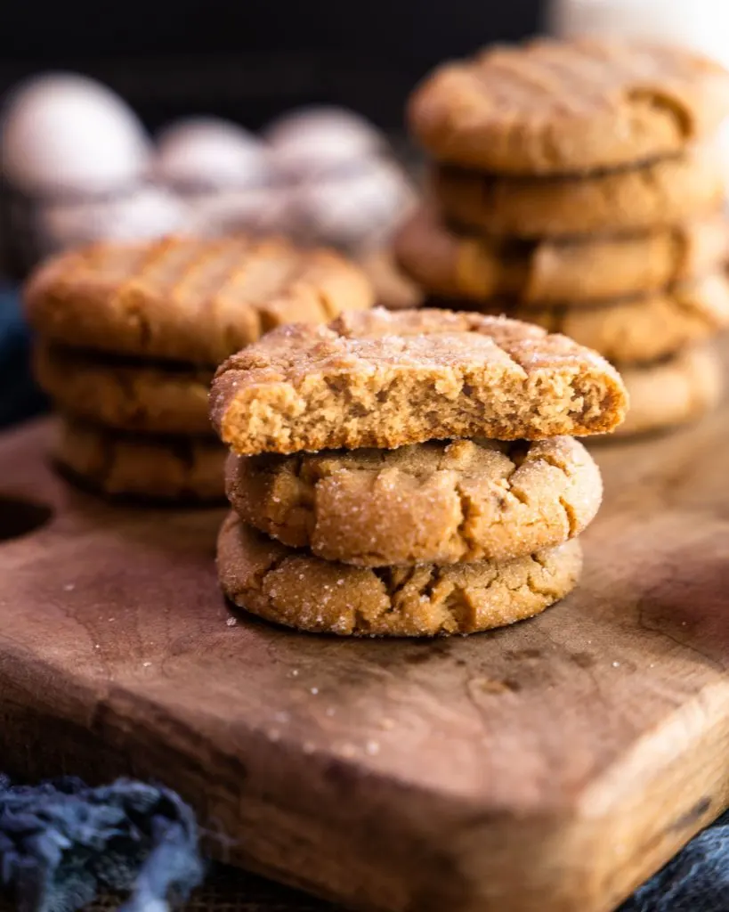 Side view of a peanut butter cookie broken in half showing a soft crumb.