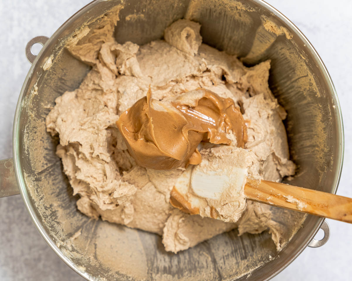 Peanut Butter added to cookie batter in a mixing bowl.