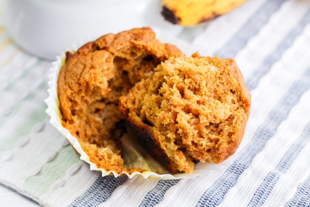 A banana pumpkin muffin that's torn in half showing a soft tender crumb. Hostess At Heart