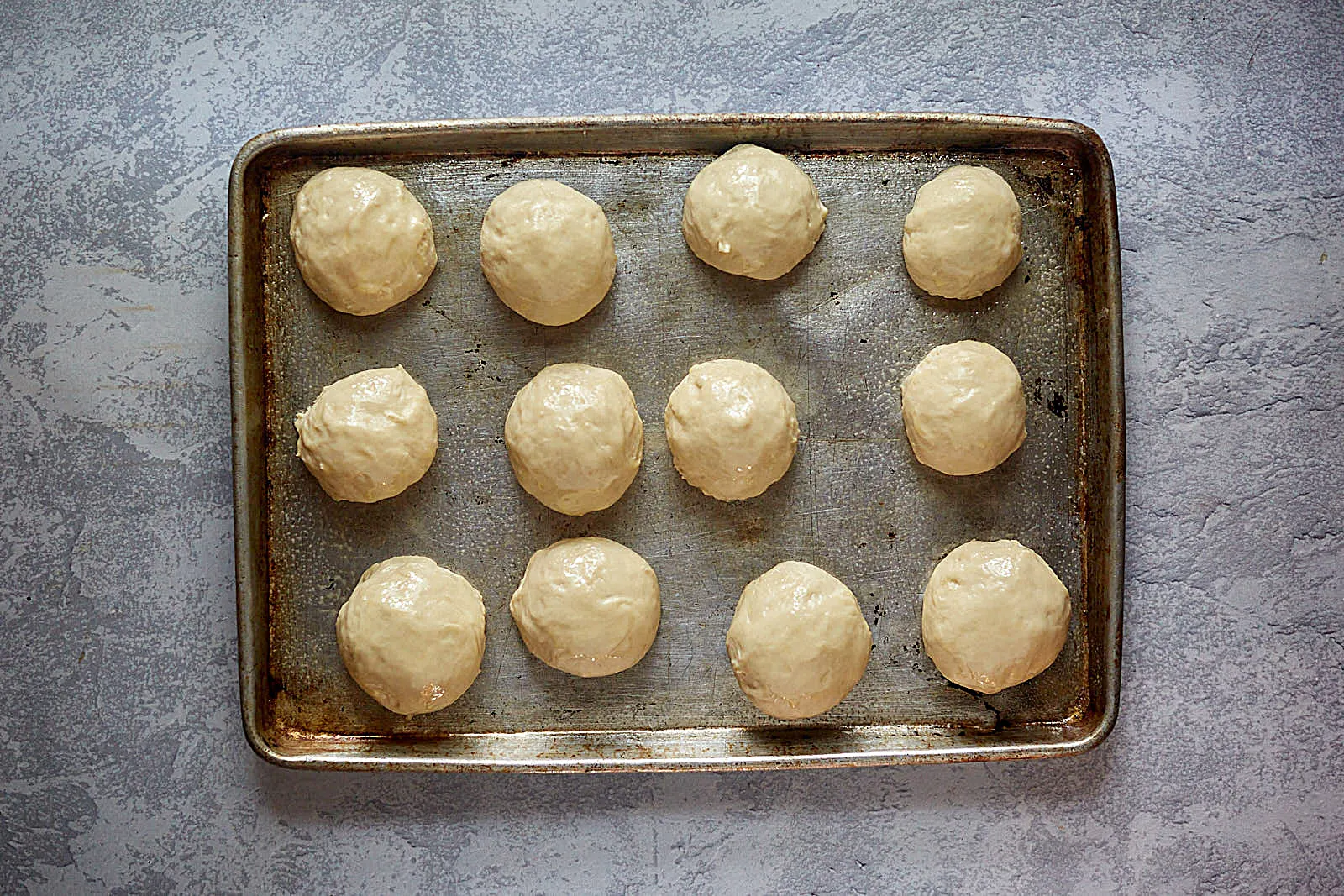 soft kolache dough formed into individual rolls on a sheet pan