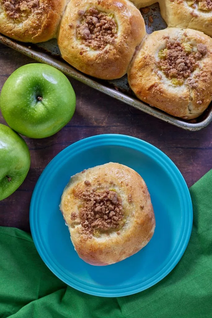 Apple Kolaches on a tray with one on a plate separated.