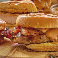 Table view of grilled chicken sandwich topped with asian peanut sauce