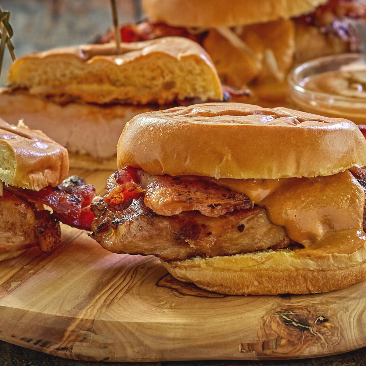 Table view of grilled chicken topped with bacon and peanut sauce.