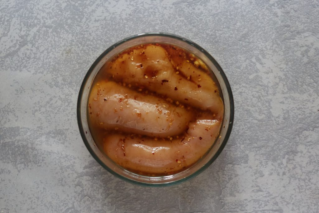 Chicken breasts marinating in a bowl