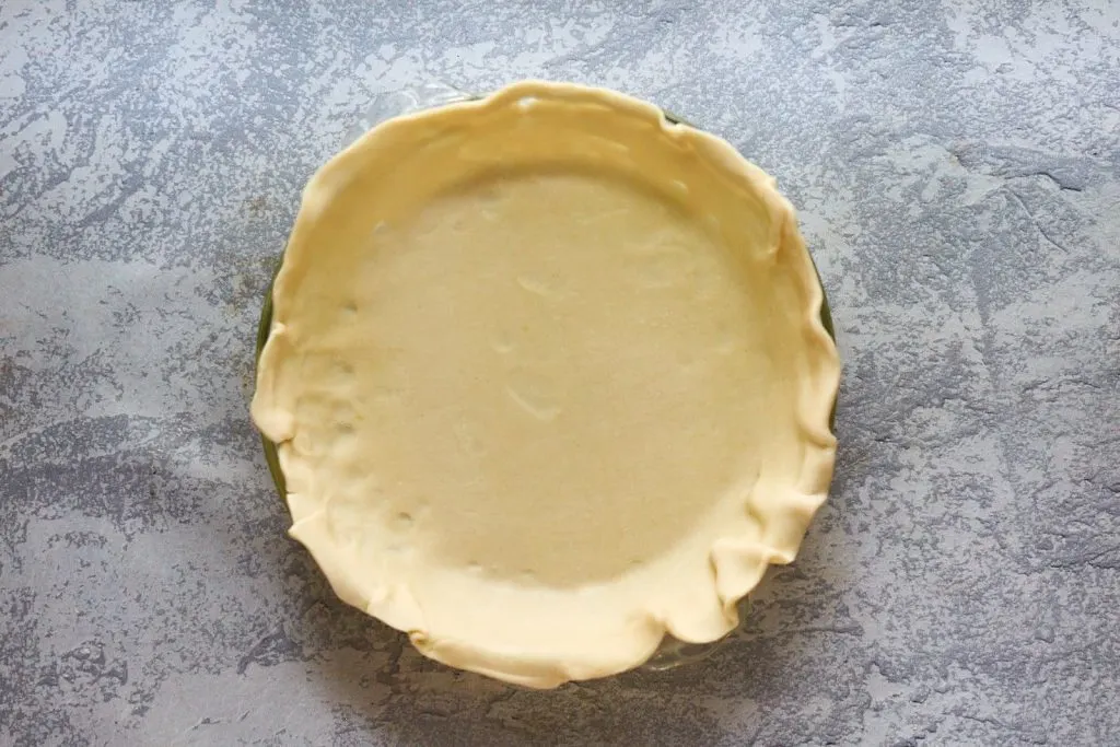 A crust rolled out and placed in a pie plate