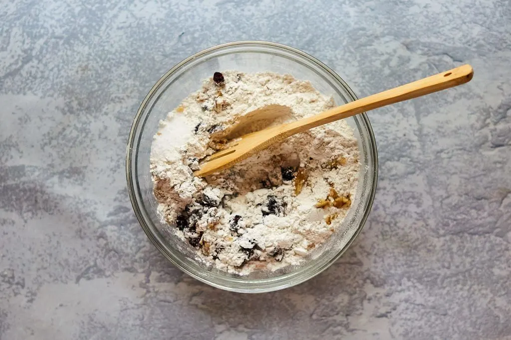 Incorporating the cranberries and walnuts into the flour mixture.