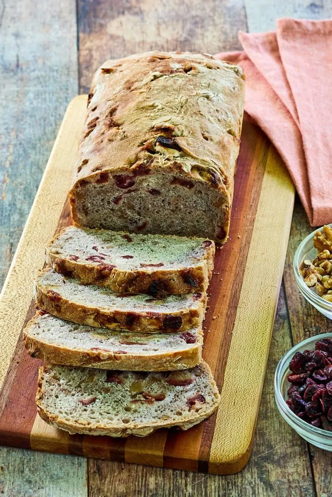 Side view of slices and loaf of cranberry walnut bread.
