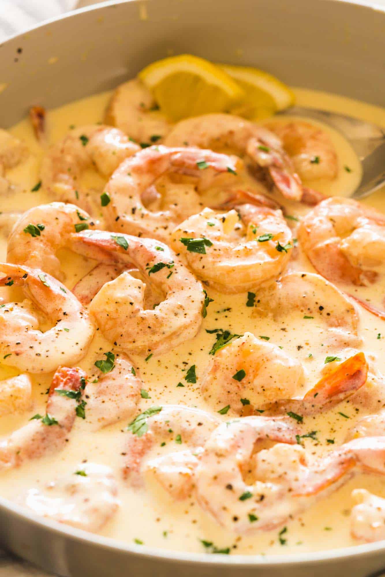 Shrimp sitting in a cream sauce in a skillet