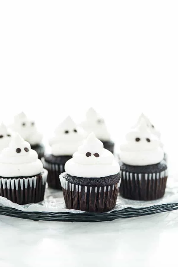 Chocolate cupcakes topped with ghosts for Halloween.